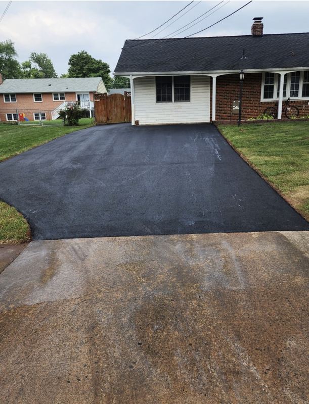 The same driveway finished in fresh asphalt after the concrete was replaced